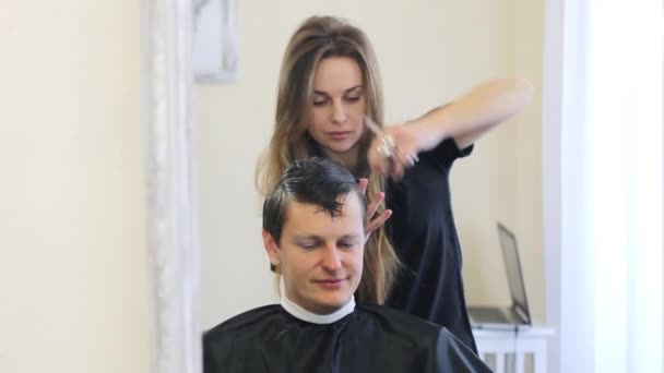 Ragazza parrucchiere rende ragazzo acconciatura — Video Stock