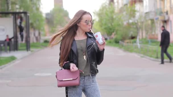 Όμορφη μελαχρινή κοπέλα πόσιμο κούνημα γάλακτος στο δρόμο — Αρχείο Βίντεο
