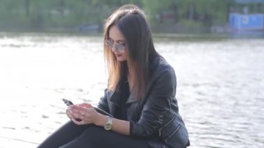 güzel kız bir nehir üzerinde oturur ve onun hareket eden aygıt kullanır