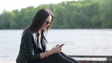 Güzel genç kadın telefonunu kullanarak