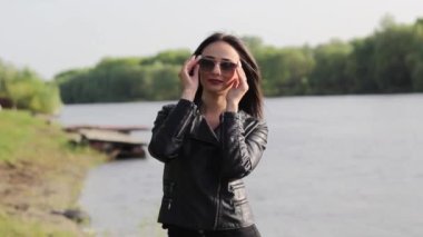 güzel bir esmer bir nehir üzerinde güneş gözlüğü takıyor