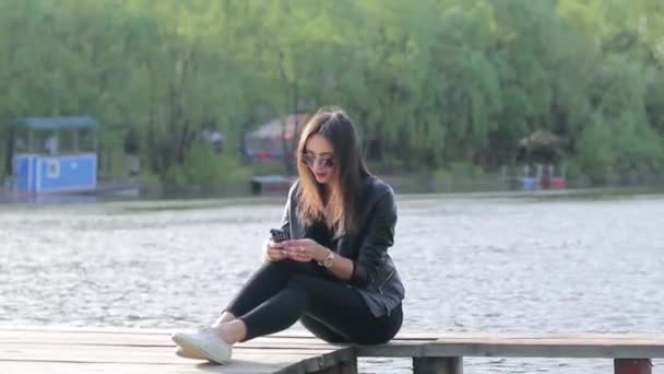 Schöne junge Frau mit ihrem Handy — Stockvideo