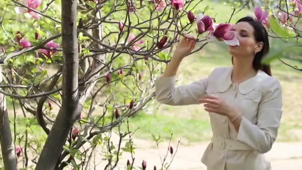 Hermosa joven en un jardín florecido — Vídeo de stock
