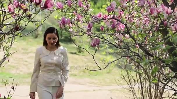 Mooi jong meisje in een bloemrijke tuin — Stockvideo