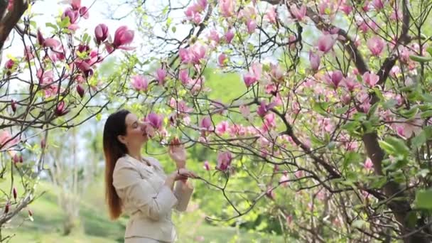 Vacker ung flicka i en blomstrande trädgård — Stockvideo