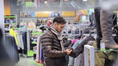 Adam mağaza kış giysileri satın alır
