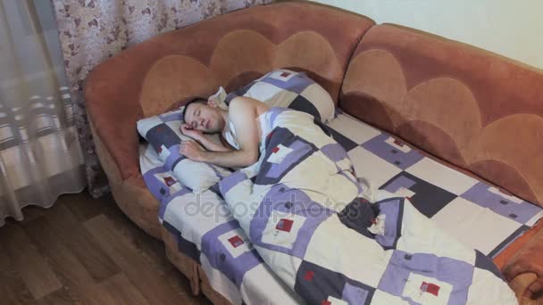 Le jeune homme dort dans le lit — Video