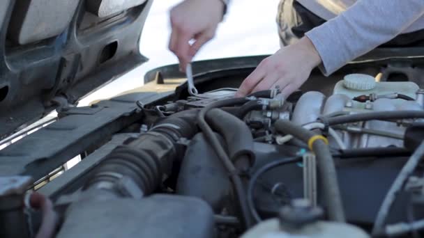 Un joven repara un coche — Vídeos de Stock