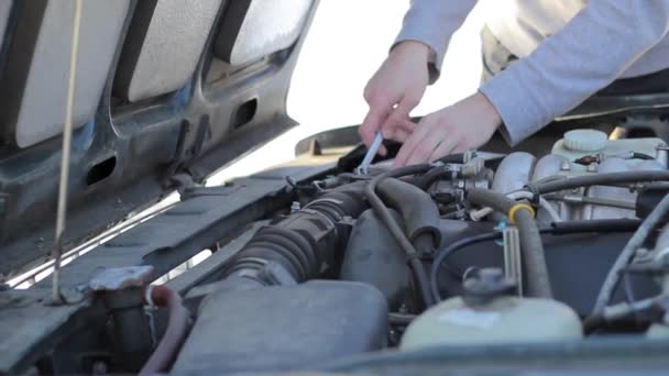 Un joven repara un coche — Vídeos de Stock