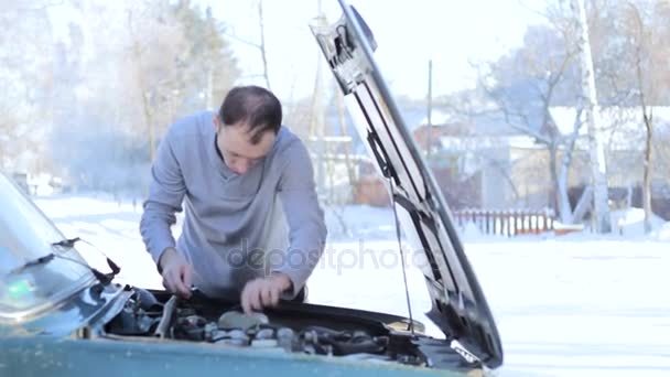 Um cara jovem repara um carro — Vídeo de Stock