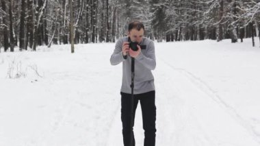 bir adam bir karla kaplı ormanda bir video çekimleri