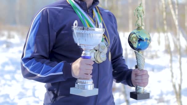 Jonge kerel atleet met medailles en bekers voor voetbal in de handen — Stockvideo