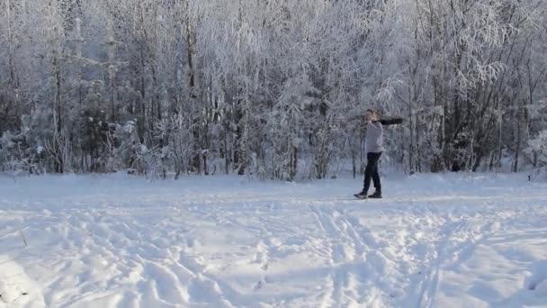 Ung kille spela gitarr i den snöiga skogen — Stockvideo