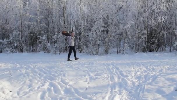 Молодий хлопець грає на гітарі в засніженому лісі — стокове відео