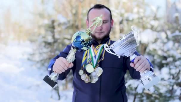 Ragazzo barbuto con medaglie e tazze sul calcio — Video Stock