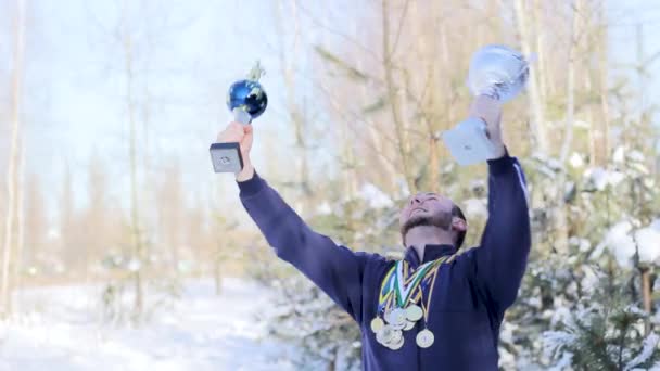 Joven deportista chico se regocija con copas y medallas — Vídeo de stock