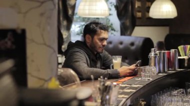 Genç zenci kafede bir cep telefonu kullanan ve kahve içiyor