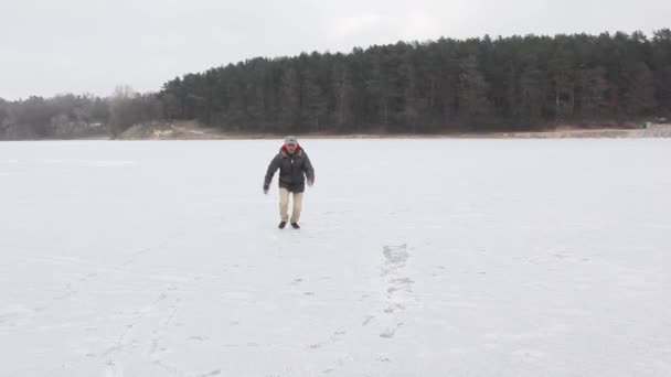 Молодой черный парень на льду возле леса — стоковое видео