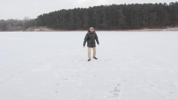 Молодий чорний хлопець ковзає на льоду біля лісу — стокове відео