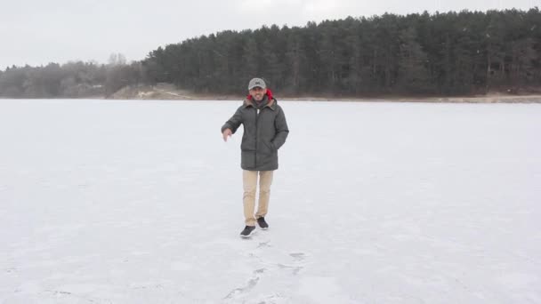 Un tipo de Dubai camina sobre hielo en un bosque nevado — Vídeo de stock