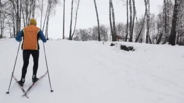 bir sporcu kayaklar üzerinde karla kaplı bir dağ tırmanma