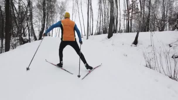 Guy skidåkare klättrar ett snöklädda berg — Stockvideo
