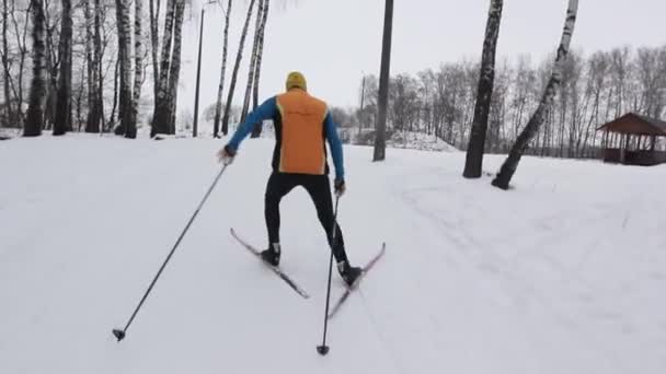 Спортсмен на лыжах взбирается на снежную гору — стоковое видео