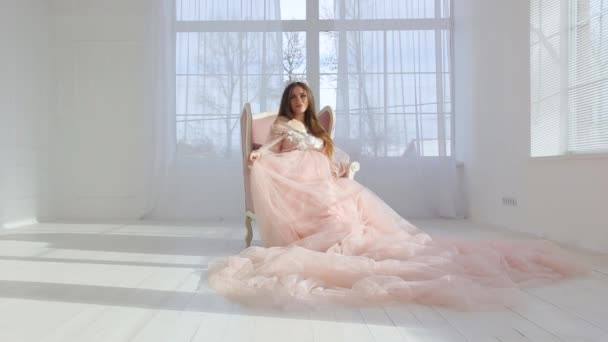 Беременная девушка в розовом шикарном платье — стоковое видео
