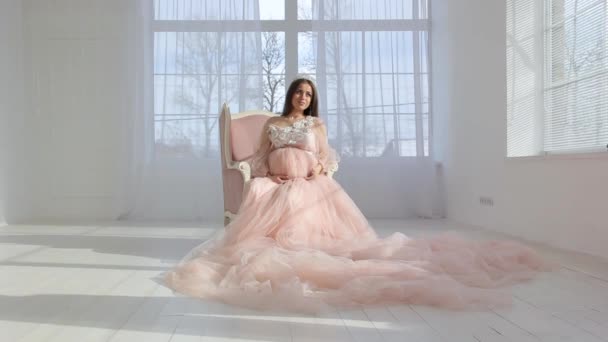 Belle jeune fille enceinte en robe longue rose — Video