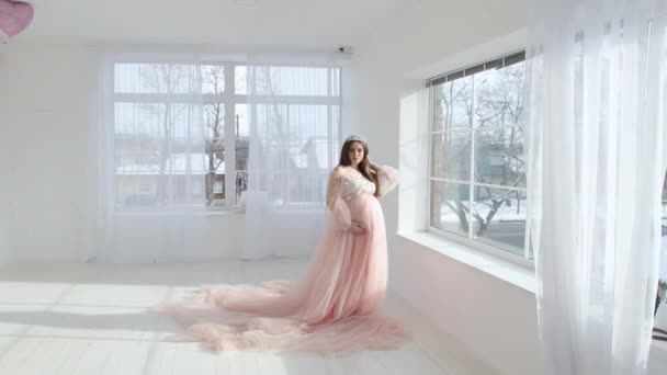 Schöne junge schwangere Mädchen in rosa langes Kleid — Stockvideo