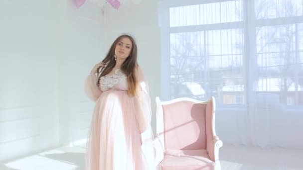 Schwangere Mädchen in einem luxuriösen rosa Kleid — Stockvideo