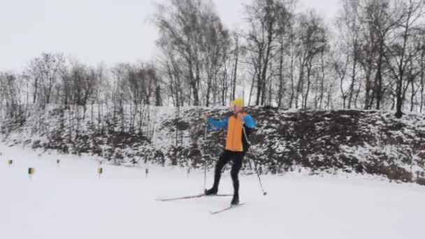 Narciarz facet na nartach podstawowej w śnieżnym lesie — Wideo stockowe