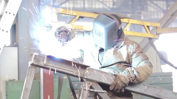 Trabajador suelda estructuras metálicas en la fábrica — Vídeos de Stock