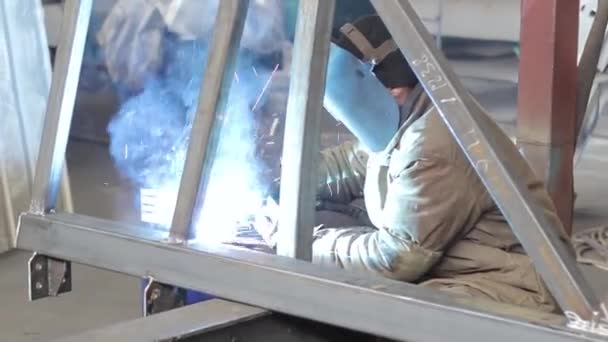 Trabajador industrial suelda un marco de metal — Vídeos de Stock