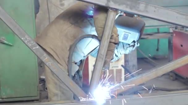 Werknemer lasnaden metalen structuren in de fabriek — Stockvideo