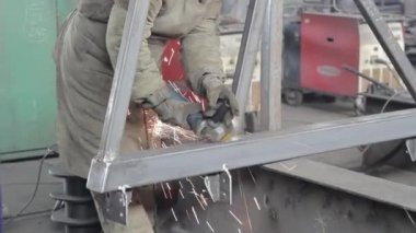 Ağır endüstri işçisi atölyede çelik boru kesiyor..