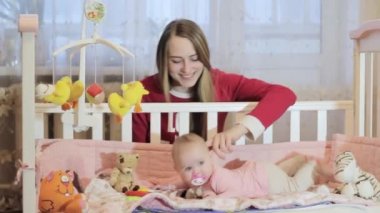 genç anne küçük kızı yatakta ile oynarken