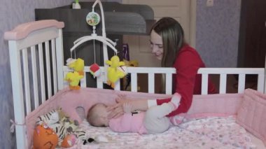 genç anne küçük kızı yatakta ile oynarken