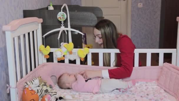 Genç anne küçük kızı yatakta ile oynarken — Stok video