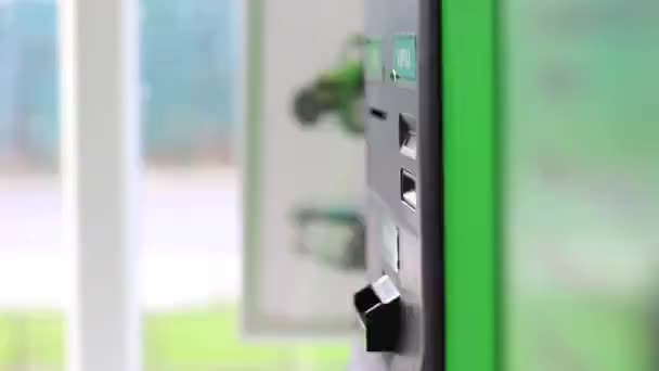 De hand van een oudere vrouw gebruikt een plastic kaart bij een pinautomaat. Oudere vrouw in een bankkantoor — Stockvideo