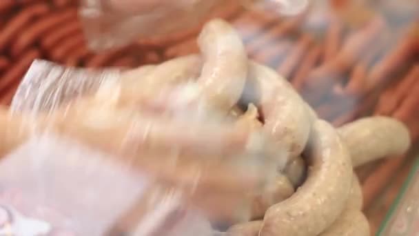 Hands worker of a sausage department worker lay sausage — Stock Video