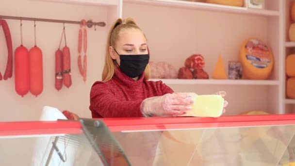 La chica en el momento de la epidemia coronovirus vende quesos y salchichas . — Vídeos de Stock