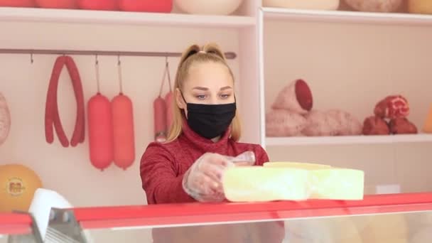 Girl smashes cheese on a showcase in a black medical mask during the coronovirus epidemic. — Stock Video