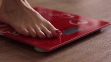 Pedikürlü güzel kadın bacakları terazide duruyor..