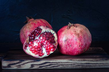 Nar, lezzetli ve siyah arka planda olgun meyveler.