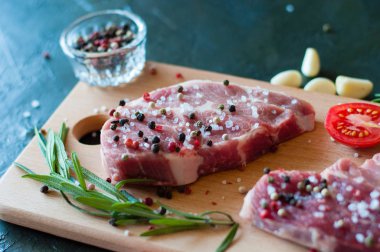 Biber ve tuz serpilmiş çiğ domuz eti doğranmış domates, sarımsak ve biberiye, biftek pişirme süreci.