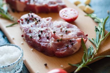 Biber ve tuz serpilmiş çiğ domuz eti doğranmış domates, sarımsak ve biberiye, biftek pişirme süreci.