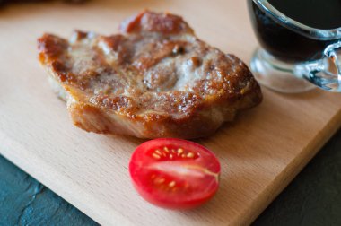 Soya soslu ızgara biftek ve bir dilim domates, yakın plan.