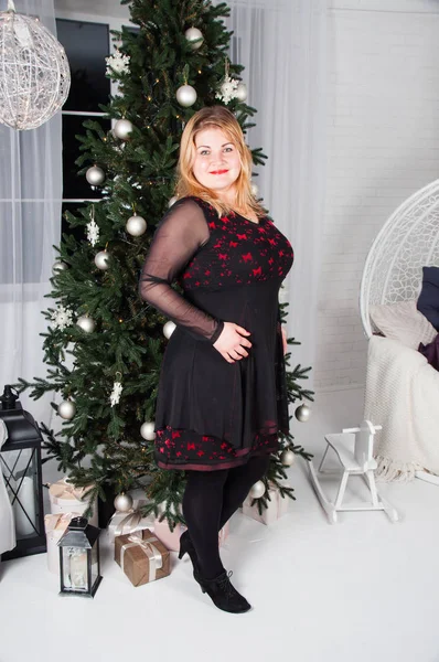 Exuberante, bela, jovem mulher perto da árvore de Natal com presentes — Fotografia de Stock