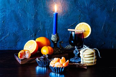 Noel zamanı, kış, cam, tarçın, portakal ve mandalina, kurabiye ve çikolata, şamdandaki mum.